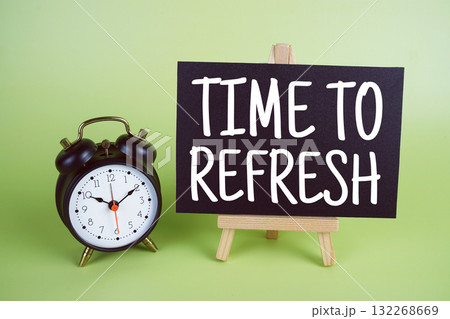 Time To Refresh text with easel and alarm clock on green background Time To Refresh text with easel and alarm clock on green background 132268669