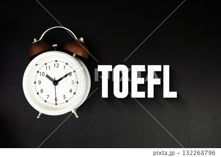 TOEFL text with alarm clock on black background 132268796