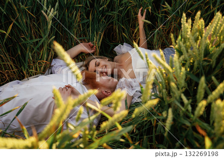 Top view, lying down. Lovely couple are on the green agricultural field together 132269198