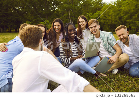 Group of happy college friends studying together outdoors and laughing at funny jokes 132269365