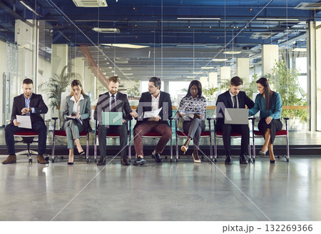 Diverse candidates sitting on chairs in row, business people applicants interns waiting 132269366