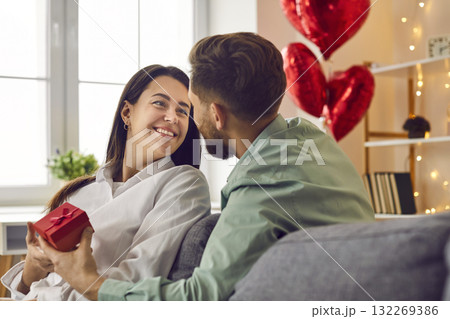 Loving man gives a romantic present to a happy young woman on St Valentine's Day Loving man gives a romantic present to a happy young woman on St Valentine's Day 132269386