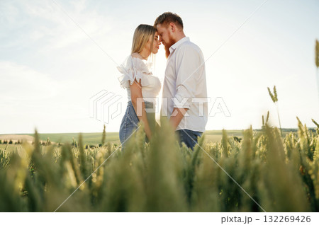 Lovely couple are on the green agricultural field together Lovely couple are on the green agricultural field together 132269426