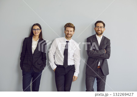 Team of happy young business people wearing formal office clothes standing by wall 132269427