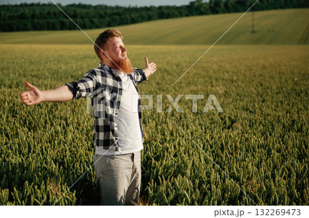 Hands to the sides, feeling the freedom. Man in white shirt is on the agricultural field Hands to the sides, feeling the freedom. Man in white shirt is on the agricultural field 132269473