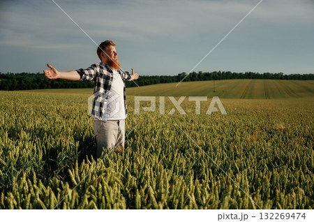 Hands to the sides, feeling the freedom. Man in white shirt is on the agricultural field Hands to the sides, feeling the freedom. Man in white shirt is on the agricultural field 132269474