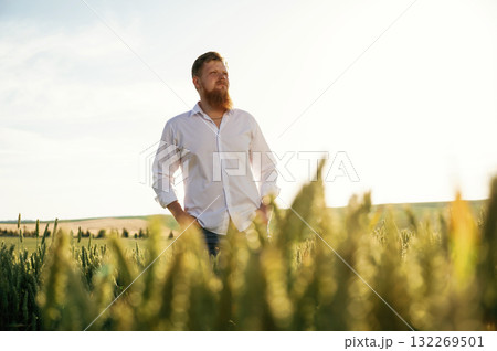 Beautiful view. Man in white shirt is on the agricultural field Beautiful view. Man in white shirt is on the agricultural field 132269501
