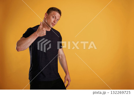 Very nice, showing thumb up. Man is against background in the studio 132269725