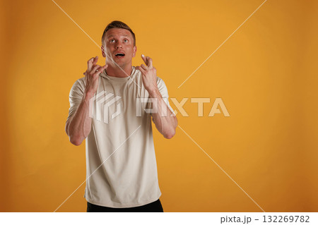 Fingers crossed, hoping for the luck. Man is against background in the studio 132269782