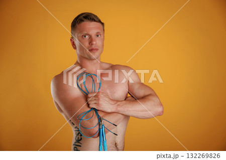 Blue jumping rope, fitness conception. Man is against background in the studio 132269826