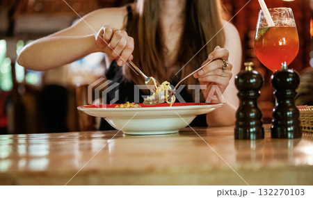 Close up view woman that is sitting in restaurant and eating food 132270103