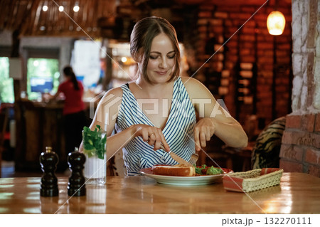 Front view. Woman is in the restaurant with food and drink Front view. Woman is in the restaurant with food and drink 132270111