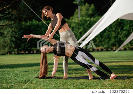 Trainer is teaching. Two fitness women are together outdoors, conception of sport Trainer is teaching. Two fitness women are together outdoors, conception of sport 132270293