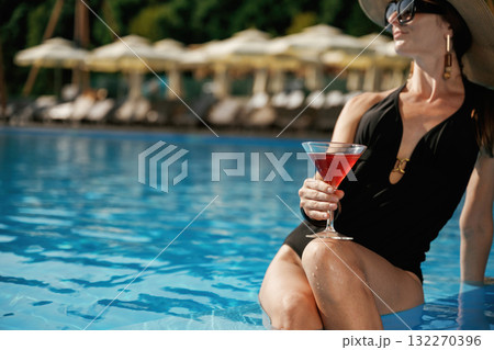 In sunglasses, with cocktail. Beautiful young woman is at resort, vacation 132270396