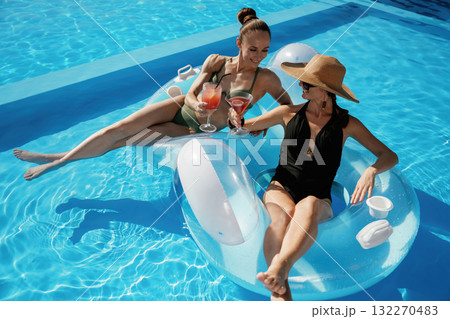 Chilling in the pool. Two beautiful women are resting Chilling in the pool. Two beautiful women are resting 132270483