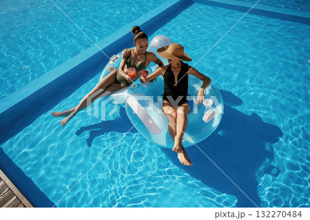 Chilling in the pool. Two beautiful women are resting Chilling in the pool. Two beautiful women are resting 132270484