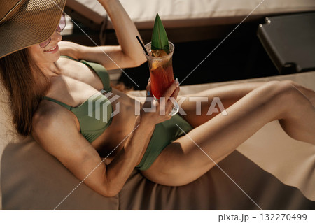 Refreshing drink in hand. Beautiful young woman is at resort, vacation Refreshing drink in hand. Beautiful young woman is at resort, vacation 132270499
