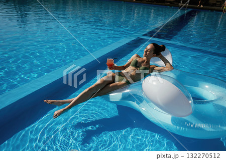 On the water in the pool. Beautiful young woman is at resort, vacation On the water in the pool. Beautiful young woman is at resort, vacation 132270512