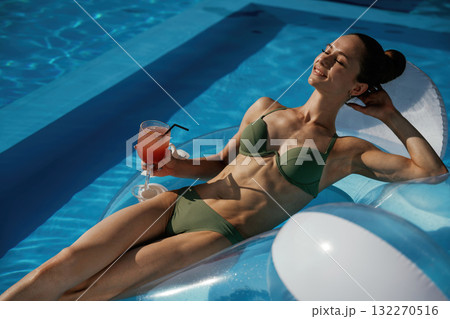On the water in the pool. Beautiful young woman is at resort, vacation 132270516