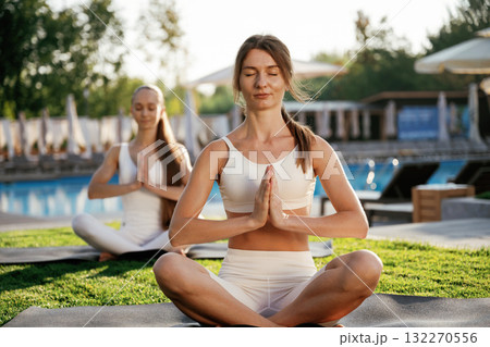 Meditation practice in lotus pose. Two fitness women are together outdoors, conception of sport Meditation practice in lotus pose. Two fitness women are together outdoors, conception of sport 132270556