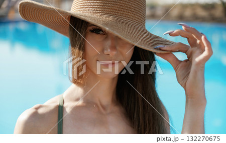 Portrait, in the straw hat. Beautiful young woman is at resort, vacation 132270675