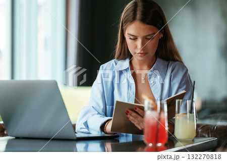 Focused at work. Beautiful woman with laptop is in the bar 132270818
