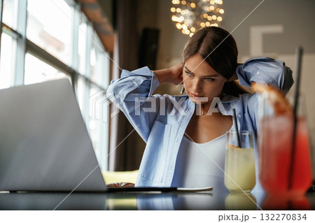 Front view. Beautiful woman with laptop is in the bar 132270834