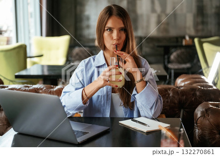 Enjoying the drink. Beautiful woman with laptop is in the bar 132270861