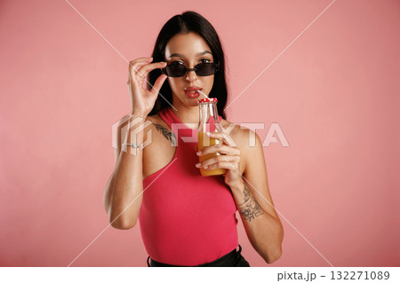 Orange juice in glass. Beautiful young woman is against background 132271089