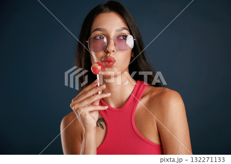 Sweet and tasty lollipop. Beautiful young woman is against background Sweet and tasty lollipop. Beautiful young woman is against background 132271133