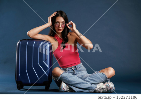 Front view, vacation, with suitcase. Beautiful young woman is against background Front view, vacation, with suitcase. Beautiful young woman is against background 132271186
