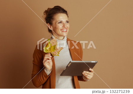 Optimistic Woman Contemplating with Tablet and Leaves 132271239