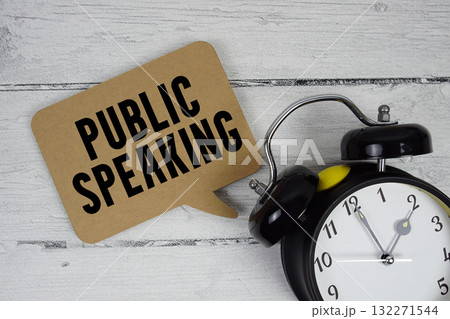 Public speaking text with alarm clock on wooden background Public speaking text with alarm clock on wooden background 132271544