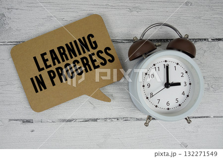 Learning in progress text with alarm clock on wooden background 132271549