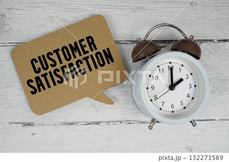 Customer satisfaction text with alarm clock on wooden background 132271569