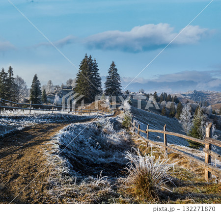 Winter coming. Last days of autumn, morning in mountain countryside peaceful picturesque hoarfrosted scene. Dirty road from hills to the village. Ukraine, Carpathian mountains. 132271870