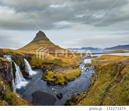 Famous picturesque Kirkjufell mountain and Kirkjufellsfoss waterfall next to Grundarfjordur at West Iceland autumn view. 132271873