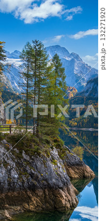 Peaceful autumn Alps mountain lake with clear transparent water and reflections. Gosauseen or Vorderer Gosausee lake, Upper Austria. Dachstein summit and glacier in far. 132271920