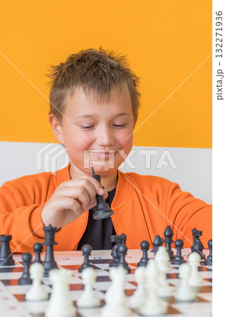 Happy school boy student playing chess in the classroom. Child with chess indoor 132271936