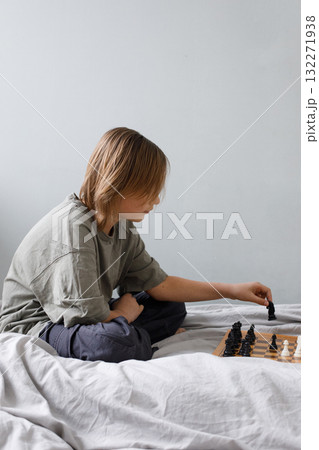 Smart child boy playing chess board game indoor. Kid 11 years old with chess at home 132271938