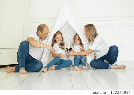 Cheerful family having fun with puppy dog pet at home Cheerful family having fun with puppy dog pet at home 132271984
