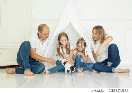 Portrait of family having fun with puppy dog pet at home Portrait of family having fun with puppy dog pet at home 132271985