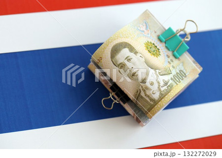Thai baht currency money bills lies on flag close up. The concept of business and investment Thai baht currency money bills lies on flag close up. The concept of business and investment 132272029
