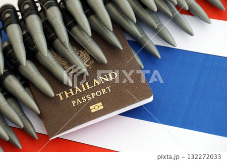 Thai passport and rifle bullets on flag close up. The concept of warfare and gun selling Thai passport and rifle bullets on flag close up. The concept of warfare and gun selling 132272033