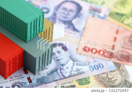 Thai baht currency money bills and toy cargo containers close up. The concept of shipping and logistics Thai baht currency money bills and toy cargo containers close up. The concept of shipping and logistics 132272047