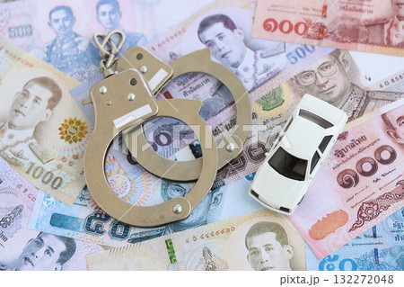 Thai baht currency money bills and toy car with handcuffs close up. The concept of car accident Thai baht currency money bills and toy car with handcuffs close up. The concept of car accident 132272048