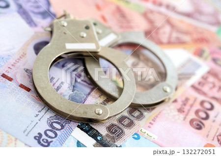 Thai baht currency money bills and handcuffs close up. The concept of criminal Thai baht currency money bills and handcuffs close up. The concept of criminal 132272051