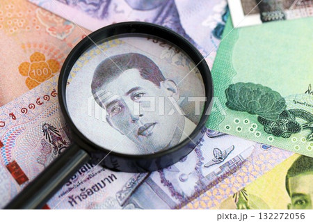 Thai baht currency money bills and magnifying glass close up. The concept of financial monitoring and taxation 132272056