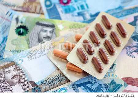 Bahraini dinar currency money bills and medicine pills close up. The concept of medicine and pharmacy Bahraini dinar currency money bills and medicine pills close up. The concept of medicine and pharmacy 132272112