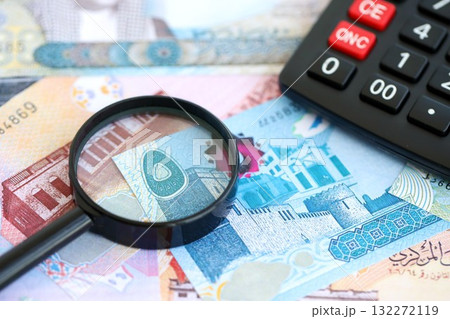 Bahraini dinar currency money bills and calculator with magnifying glass close up. The concept of taxation and money count 132272119